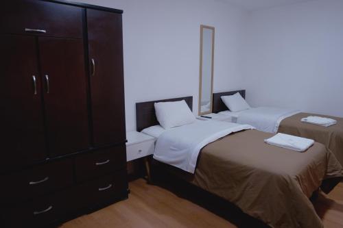 a bedroom with two beds and a dresser at Hotel San Martín in San Juan de Marcona
