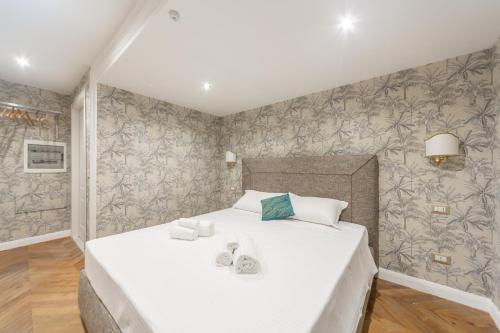 a bedroom with a white bed with shoes on it at Duomo Smart Suites in Milan
