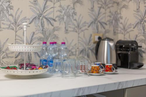 a counter with glasses and bottles on it at Duomo Smart Suites in Milan