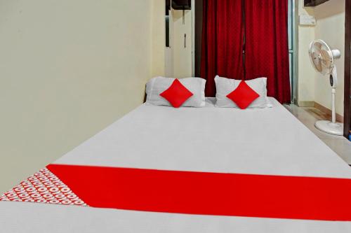 a red and white bed with two red pillows at Super Hotel O Home Town in Patna