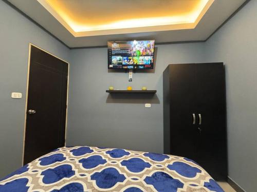 a bedroom with a bed and a tv on the wall at Apartamento Totalmente Equipado in Mixco