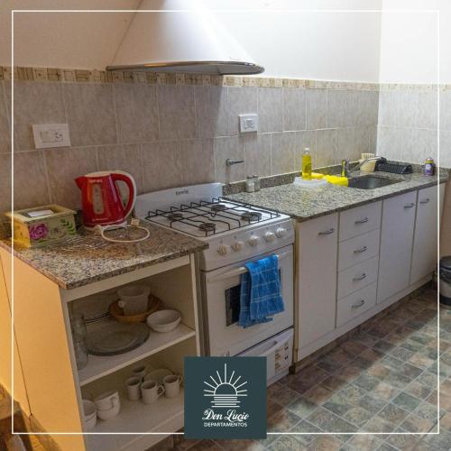 a small kitchen with a stove and a sink at Don Lucio Departamentos in Carhué