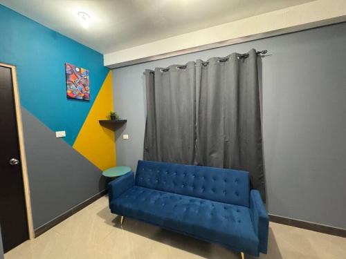 a blue couch in a room with a curtain at Apartamento Totalmente Equipado in Mixco