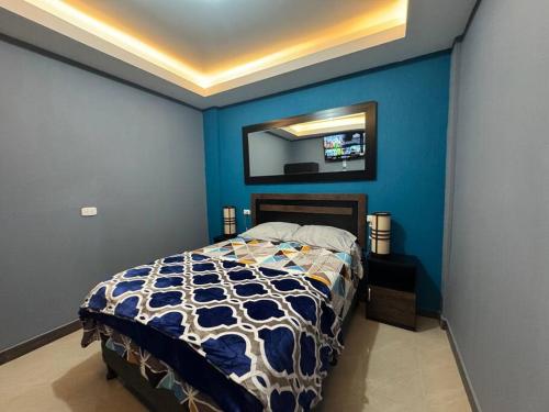 a blue bedroom with a bed and a mirror at Apartamento Totalmente Equipado in Mixco