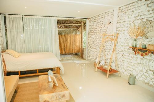 1 dormitorio con 1 cama en una habitación con una pared de ladrillo en Cabañas Tranquilidad Total, en Gaira