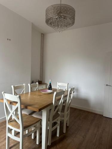 a dining room with a wooden table and white chairs at Arthur Street, Stylish 3 Bedroom House in Hull