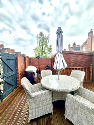 a patio with chairs and a table with an umbrella at Arthur Street, Stylish 3 Bedroom House in Hull