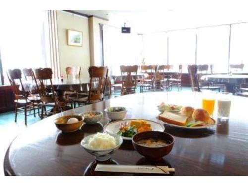 a table with bowls of food on it with a table with chairs at Terminal Art Inn - Vacation STAY 97347v in Niigata