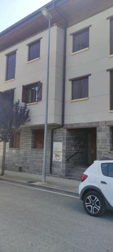 a white car parked in front of a building at Apartamento EL RIO in Biescas