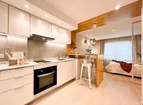 eine Küche mit weißen Schränken und einem Herd mit Backofen in der Unterkunft Las Toscas in Mar del Plata