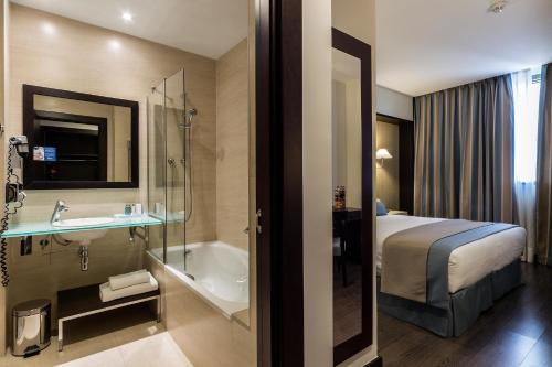 a hotel room with a bed and a bath tub at LCB Hotel Fuenlabrada in Fuenlabrada