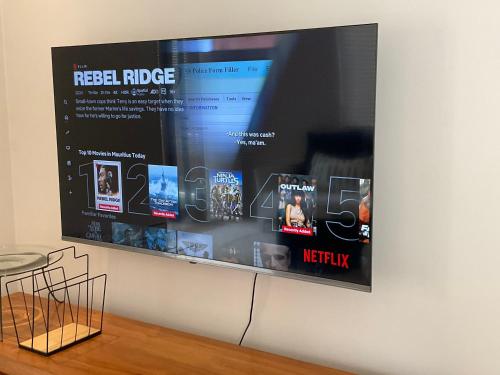 a flat screen tv hanging on a wall at Blue Waves Beachfront Penthouse in Flic-en-Flac