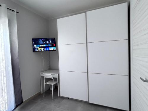 a white closet with a tv on a wall at Donnicalia in Serramanna