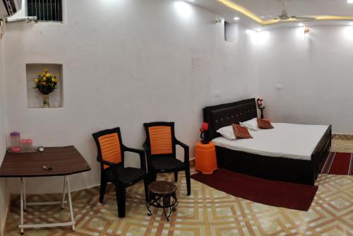 a room with a bed and a table and chairs at A ShivAngan Heritage Home Stay Near Ghat in Varanasi