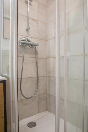 une douche avec pommeau de douche dans une salle de bain dans l'établissement Charmant appartement T1 Mâcon, à Mâcon