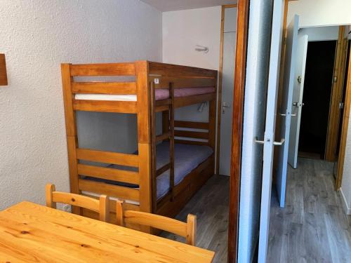 Cette chambre comprend une table et des lits superposés. dans l'établissement Résidence Soldanelles Villages - Studio divisible 4 personnes - Plagne Village MAE-4834, à La Plagne Tarentaise