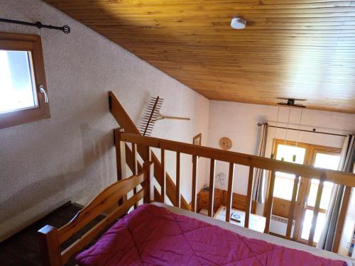 Cette chambre dispose d'un escalier, d'un lit et d'une fenêtre. dans l'établissement Résidence Hameaux I - Studio mezzanine 4 personnes - Plagne Village MAE-4704, à La Plagne Tarentaise