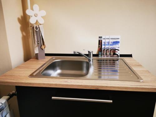 a kitchen sink with a book sitting on top of it at Central Park Apartman in Szekszárd
