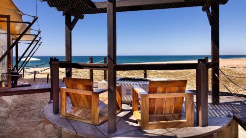 a gazebo with two chairs and the beach at Villa Santa Cruz in Todos Santos