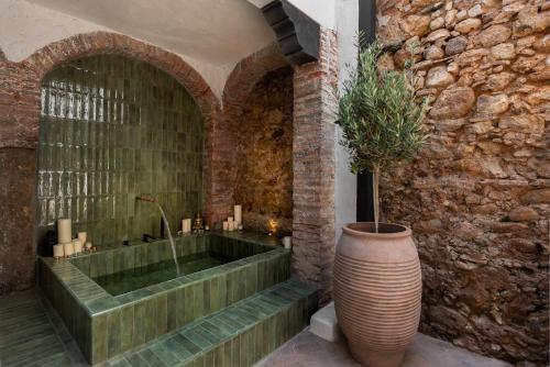 un baño con bañera con una planta en un jarrón en Casa Azalia - Marbella Old Town, en Marbella
