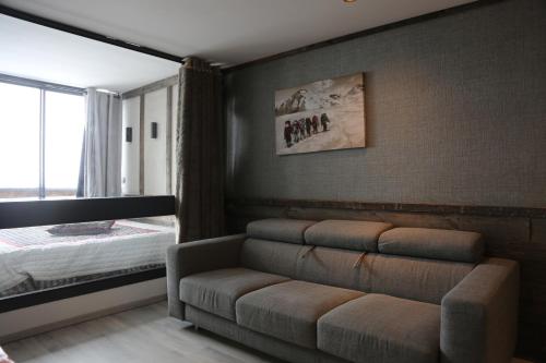un salon avec un canapé et un lit dans l'établissement Val Tho - New - Ski in - Near slalom, à Val Thorens