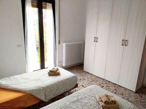 a bedroom with two beds and a large window at Affitti brevi - Casa Emy in Arcisate