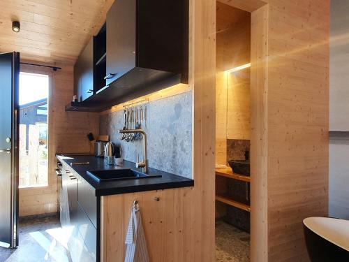 a kitchen with wooden walls and a sink at Werder Chalet -- WOLKE 7 -- Ostsee-Strand 150m I Sauna I eKamin I Tiny House für 2 Personen I by "Meyers am Meer" in Boiensdorf