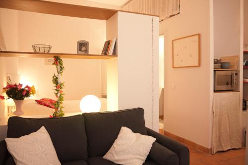 uma sala de estar com um sofá preto num quarto em Studio Apartment Centre Historique em Arles