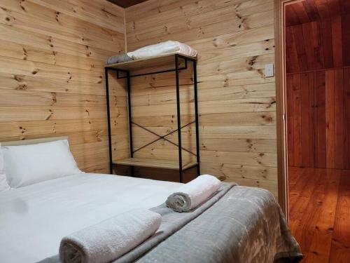a bedroom with a bed and a wooden wall at Mt Elephant Bush Retreat - Gray in Gray