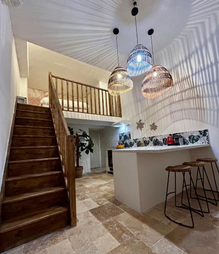 une cuisine avec un escalier et des lampes suspendues dans l'établissement Cœur cannois avec terrasse, clim et jacuzzi, à Cannes