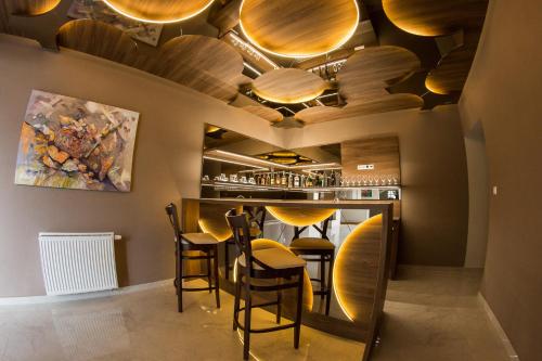 a bar with wooden ceilings and stools in a restaurant at Penzión Tri Koruny in Spišská Stará Ves
