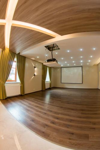 a large room with a wooden ceiling and a projection screen at Penzión Tri Koruny in Spišská Stará Ves