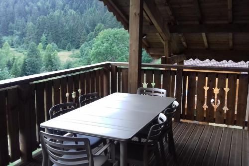 a table and chairs on the deck of a cabin at L'appart des familles sportives! in La Bresse