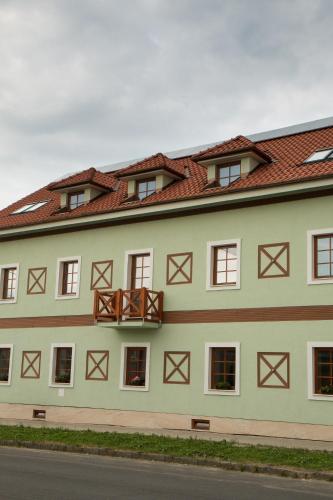 a large white building with a red roof at Penzión Tri Koruny in Spišská Stará Ves