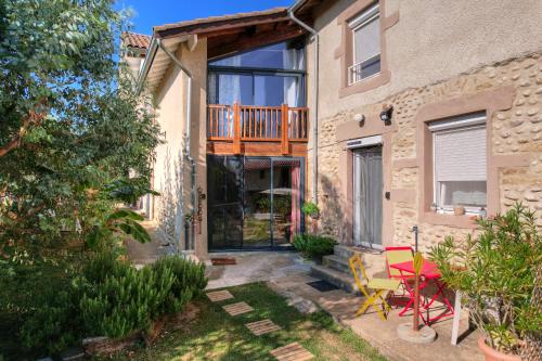 a home with a deck and a patio at Les Figuets in Châteauneuf-de-Galaure
