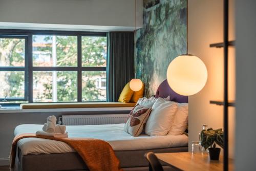a bedroom with a bed and a window at Badhuis Hotel in Utrecht