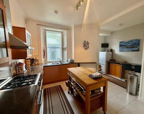 a large kitchen with a stove and a sink at Bayside - Breathtaking views of the Clyde in Rothesay