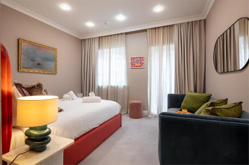 a bedroom with a bed and a chair and a lamp at Impressive 5Beds House in South Kensington in London