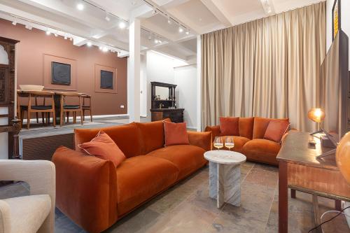 a living room with an orange couch and a table at Impressive 5Beds House in South Kensington in London