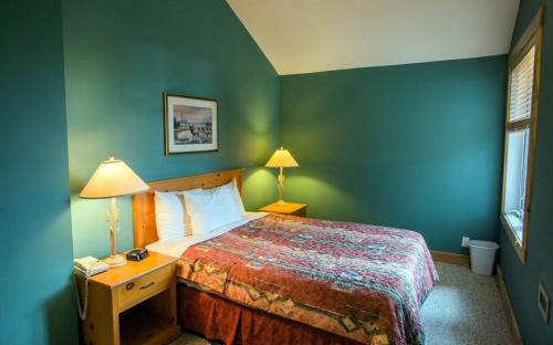 - une chambre avec un lit aux murs verts dans l'établissement Cornerstone Lodge by Park Vacation Management, à Fernie
