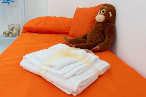 a stuffed monkey sitting on a bed with a pile of towels at The Castle of Etna in Trecastagni