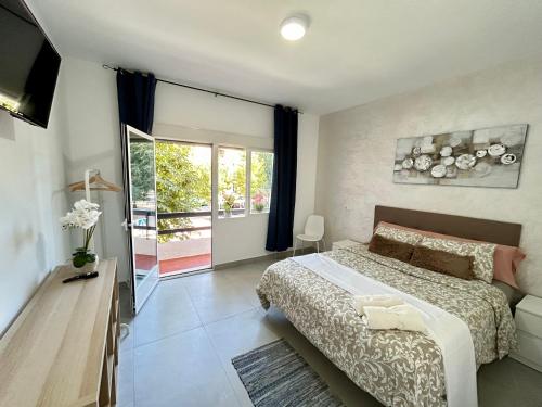 a bedroom with a large bed and a balcony at Rooms Getafe in Getafe