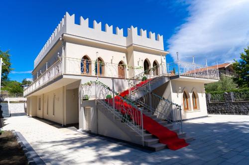 a white building with red stairs in front of it at The Castle of Etna in Trecastagni