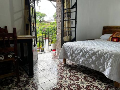 a bedroom with a bed next to a balcony at Rosita in Taxco de Alarcón