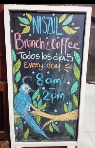 Un cartel con un pájaro azul posado en la rama de un árbol. en Yuu-Lee Casa Bendita Huatulco, en Santa Cruz Huatulco