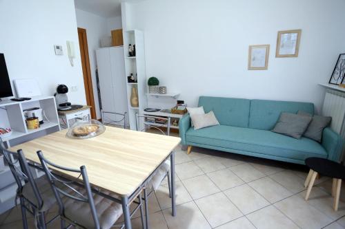 a living room with a blue couch and a table at La casetta di Lorena in Clusone