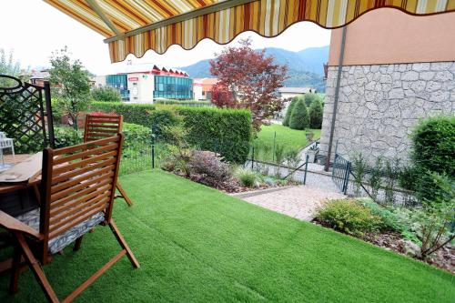 a patio with a table and a bench on a lawn at La casetta di Lorena in Clusone