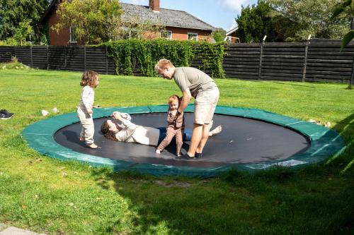 a man and two children playing on a trampoline at Sdr. Omme Bed & Breakfast in Sønder Omme