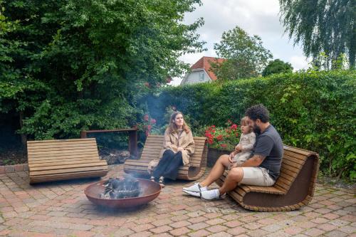 a group of people sitting around a fire pit at Sdr. Omme Bed & Breakfast in Sønder Omme