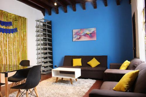 a living room with a couch and a blue wall at La casa del mochilero in Mexico City
